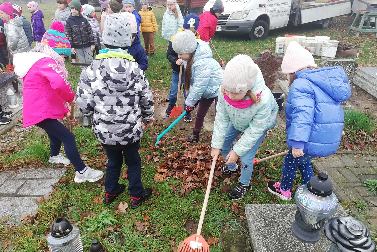Przedszkolaki sprzątają cmentarz, grabią liście