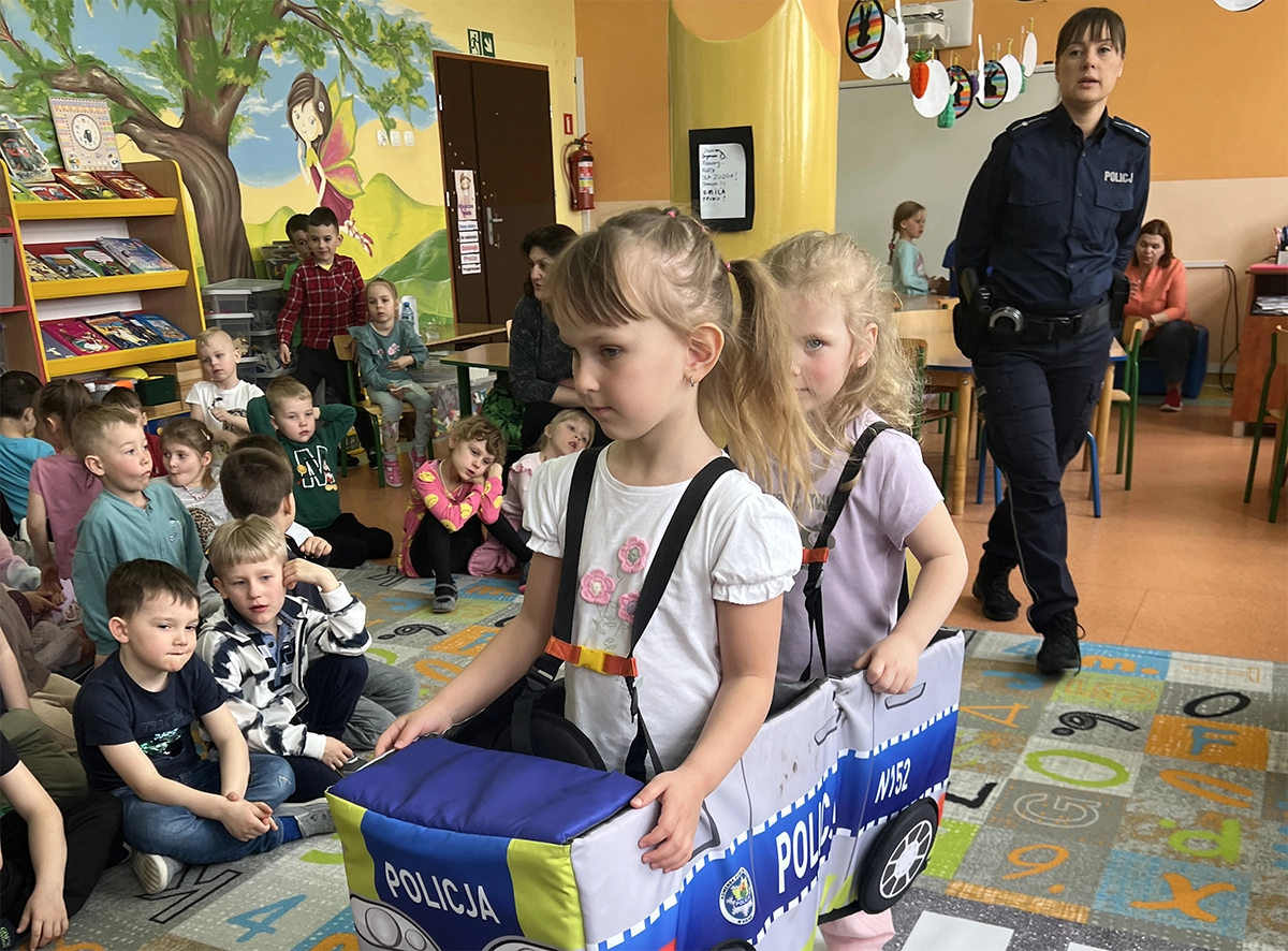 dzieci biorą udział w zabawach edukacyjnych prowadzonych przez panią policjantkę